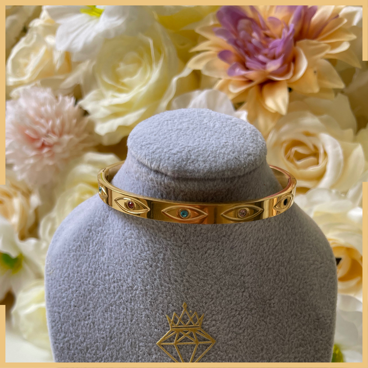 Goldener Armreif mit Schutzsymbol & bunten Edelsteinen – Elegant & Zeitlos