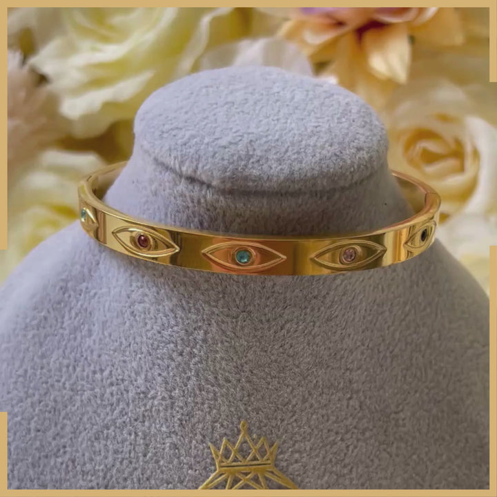 Goldener Armreif mit Schutzsymbol & bunten Edelsteinen – Elegant & Zeitlos